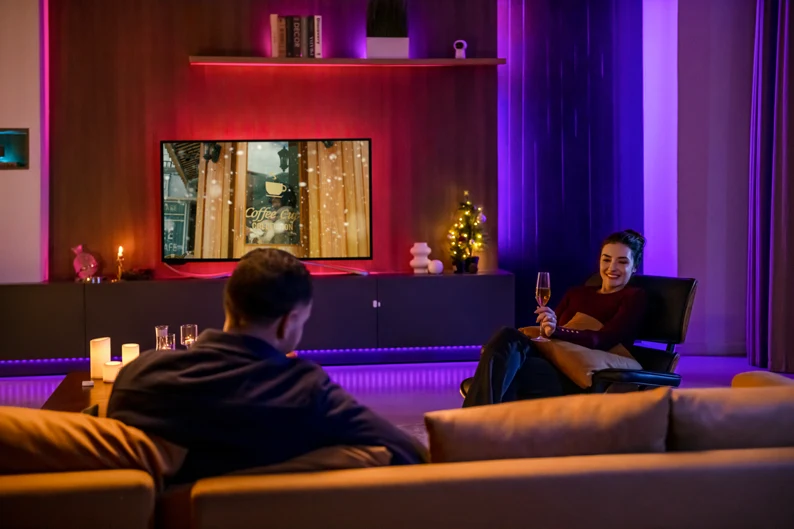 Living room with Aqara coloured accent lighting during movie night