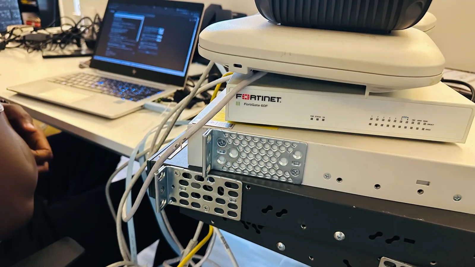 Network equipment and wireless access points connected beside a laptop on a workbench